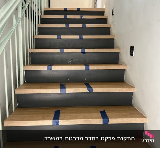 מדרגות עץ עם סרטי סימון כחולים